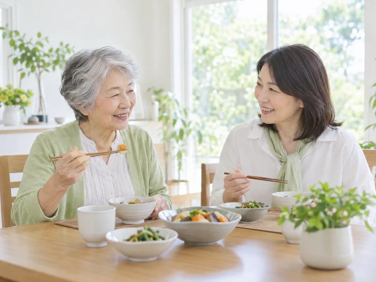 明るい食卓で、70代の女性が娘と一緒に食事をしている