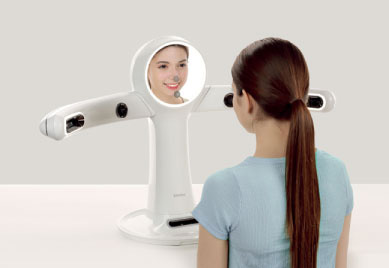 RAYFace の前に座り、カメラに向かって撮影している女性