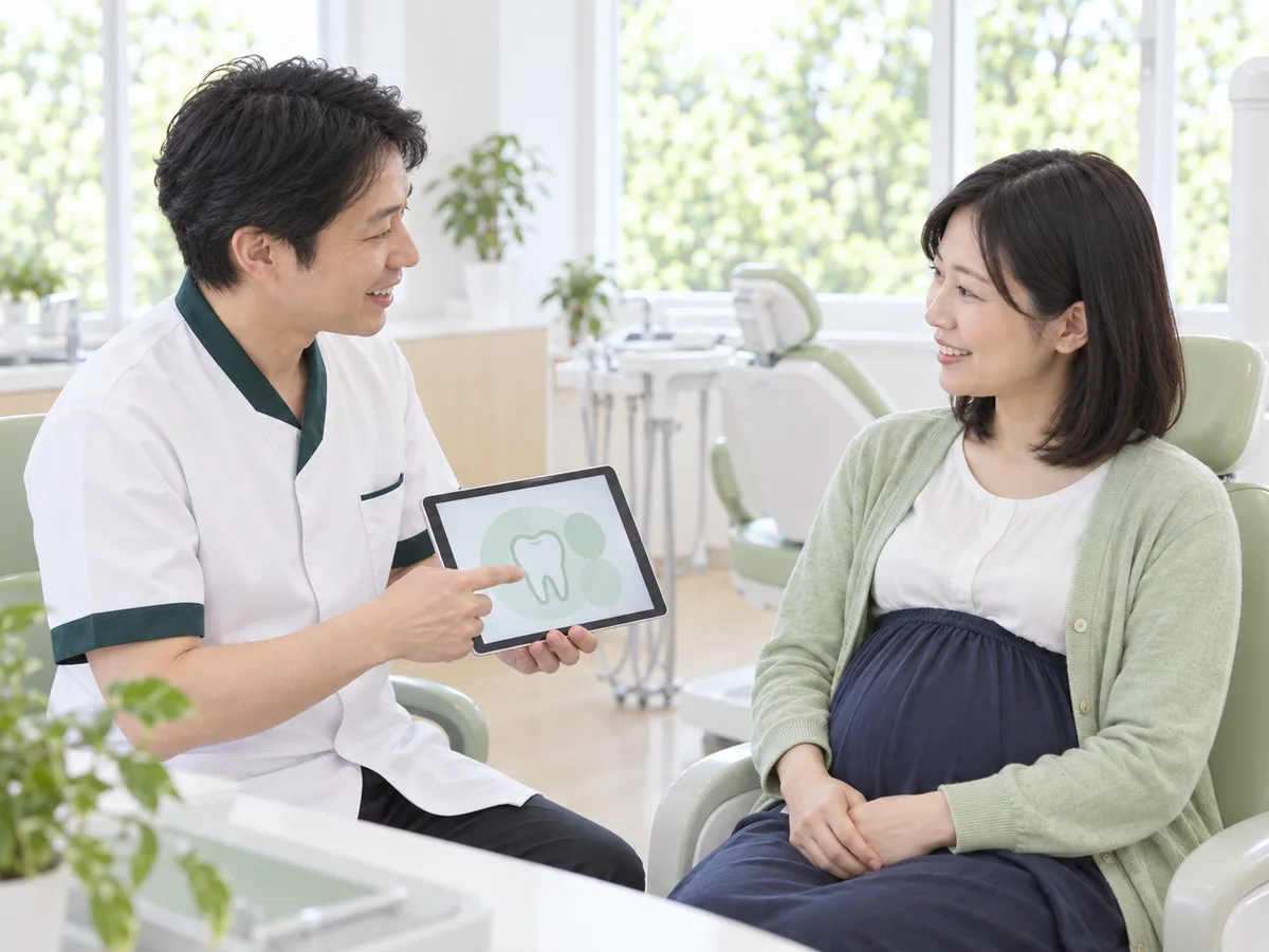 診療台に体を起こして座った妊婦さんに、歯科医師が穏やかに話しかけている