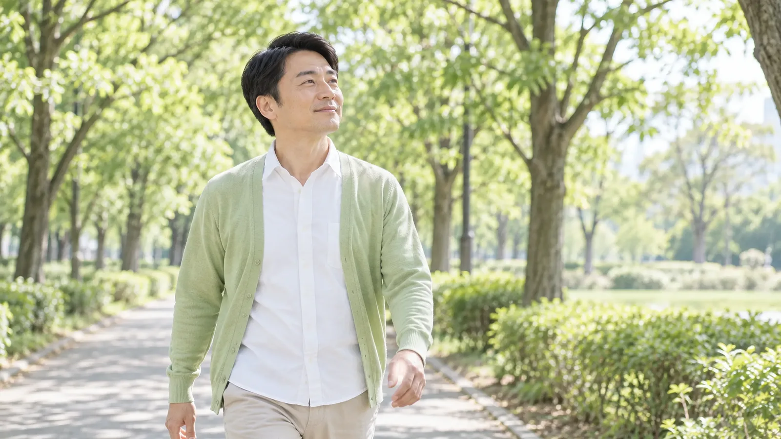 朝の公園を、40代の男性が気持ちよさそうに散歩している